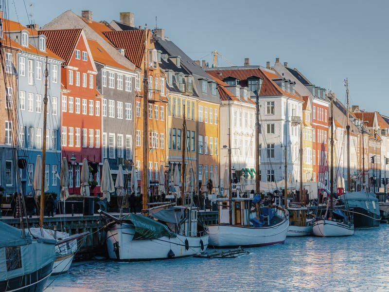 The coloured townhouses and moored wooden boats of Nyhavn in Copenhagen