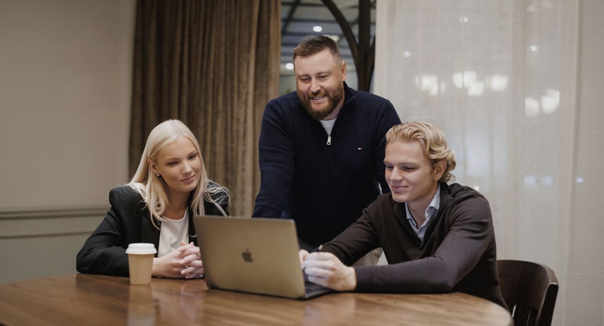 A sales coach talking with a rep at a desk